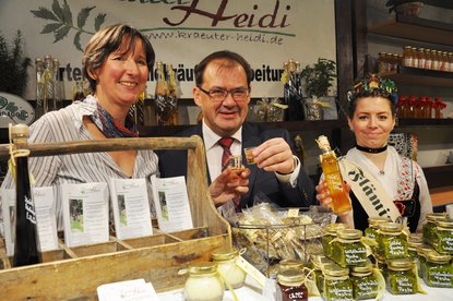 Minister Vogelsänger gemeinsam mit Kräuter-Heidi und der Fläming-Königin am Stand des Landkreises