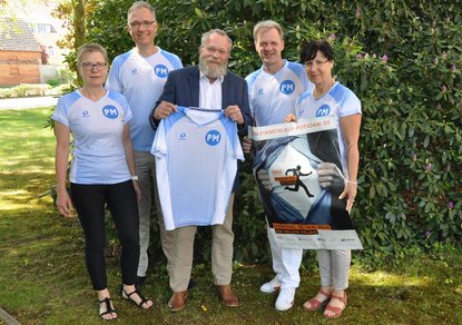Team-Captain Elke Slabon (re.) erhält von Landrat Blasig (M.) die neuen Lauf-Shirts